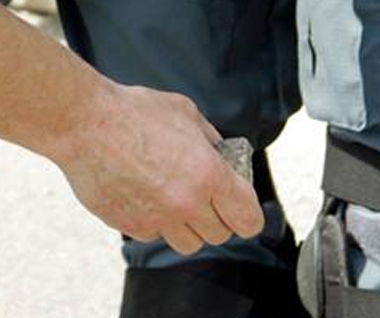 Il poliziotto che lancia una pietra