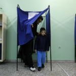 Elezioni in Grecia, un padre vota con suo figlio al seggio di Atene