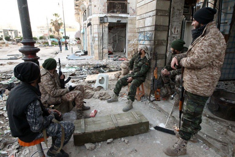 Libyan soldiers, loyal to Libya's internationally recognised government of Abdullah al-Thani and General Khalifa Haftar, rest on a sidewalk in the eastern coastal city of Benghazi on February 28, 2015. Benghazi is one of the less stable areas of the North African state, which has been plunged into chaos since the 2011 revolution that toppled dictator Moamer Kadhafi. AFP PHOTO / ABDULLAH DOMA (Photo credit should read ABDULLAH DOMA/AFP/Getty Images)