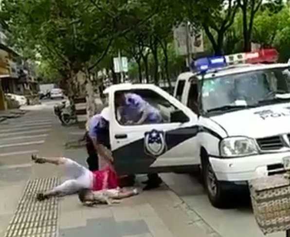 Shangai poliziotto colpisce con un pugno una mamma | VIDEO