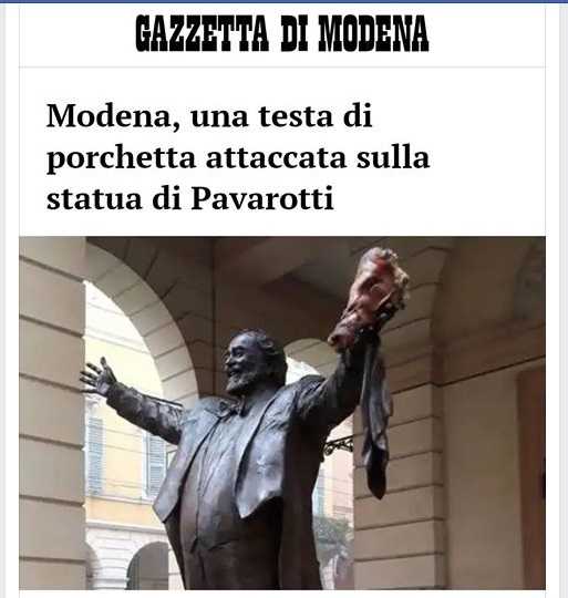 La testa di porchetta sulla statua di Luciano Pavarotti a Modena