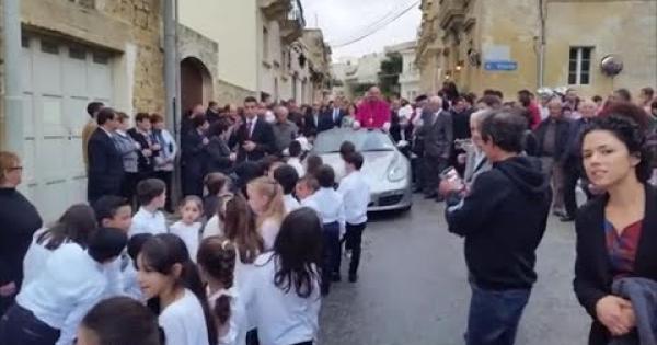A Malta, il nuovo arcivescovo gira su una Porsche trainata da bambini | VIDEO