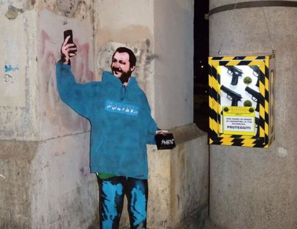 Il murale di Salvini con la divisa, lo smartphone per i selfie e le pistole | VIDEO