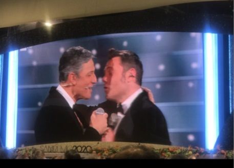 Fiorello bacia Tiziano Ferro durante il loro primo duetto della serata