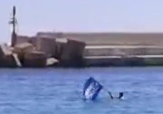L’uomo che si butta in acqua con la bandiera «Prima gli italiani» per protestare contro gli sbarchi a Lampedusa