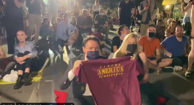 Giuseppe Conte si siede a terra e assiste al debutto della stagione del Cinema America