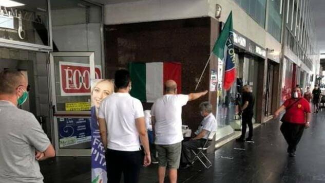 La foto dell’uomo che fa il saluto romani davanti al banchetto di FdI a Parma