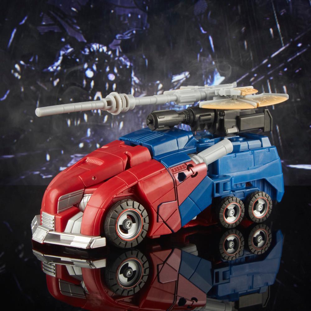 Optimus Prime Studio Series Gamer Edition 03 in modalità camion cybertroniano rosso e blu, con armi sul veicolo.
