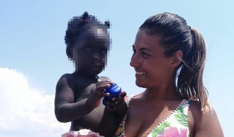 La mamma che accudisce la figlia di una venditrice ambulante sulla spiaggia di Scauri La mamma che accudisce la figlia di una venditrice ambulante sulla spiaggia di Scauri